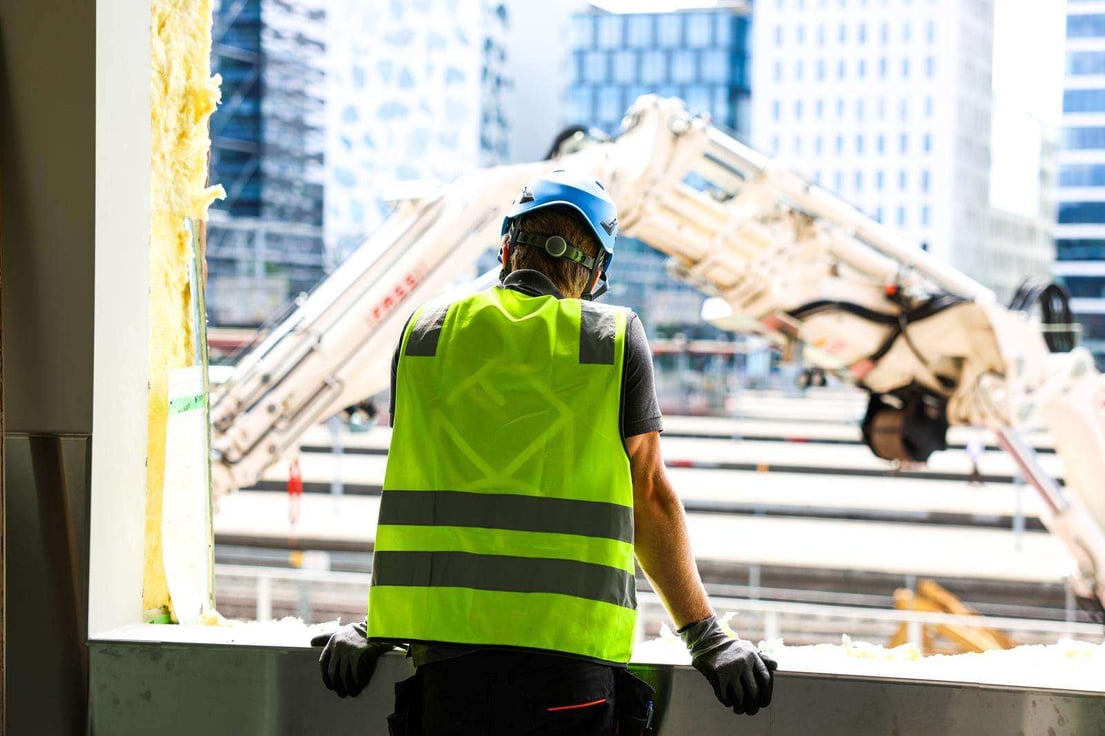 Prosjektleder ser ut av vinduet på byggeplass 